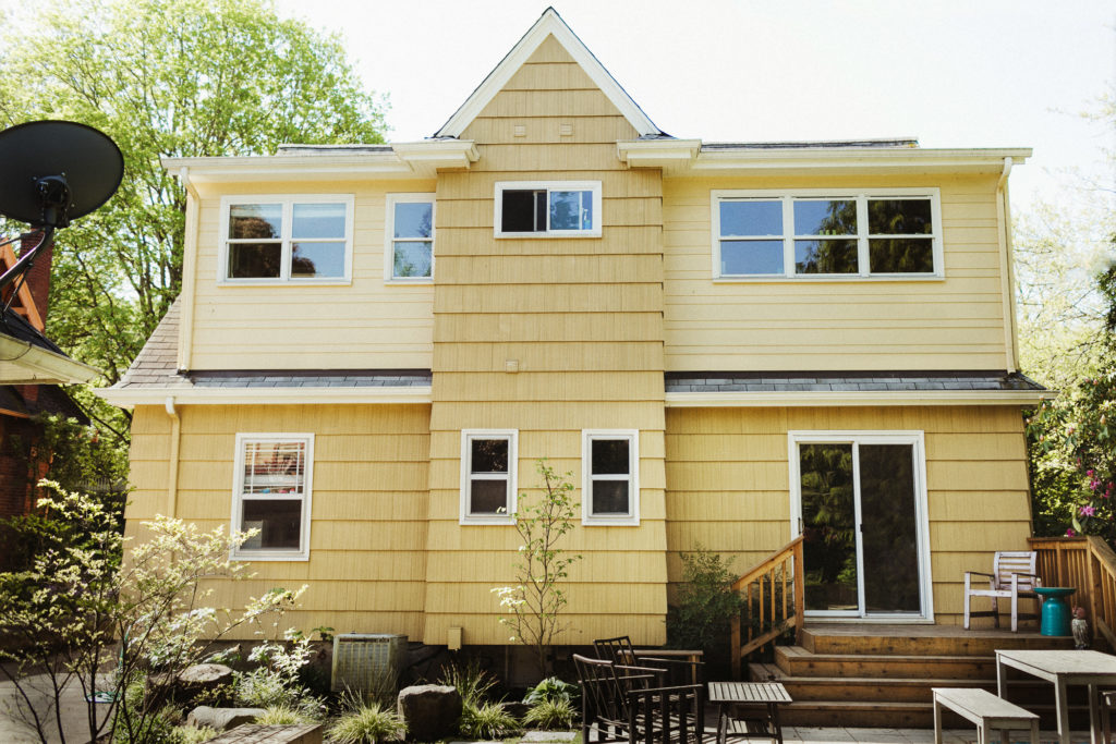 Yellow bungalow house with a single pitch large dormer and a projecting gable dormer.