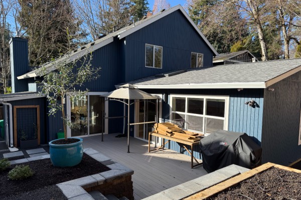 A single story addition is added to the original home, gable roof, windows and sliding patio door