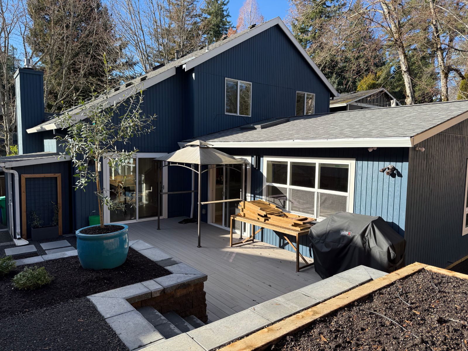 Exterior of a two story home with an addition. Gable ends. Dark blue.